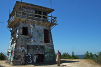 David stands before the graffiti-covered lookout tower.