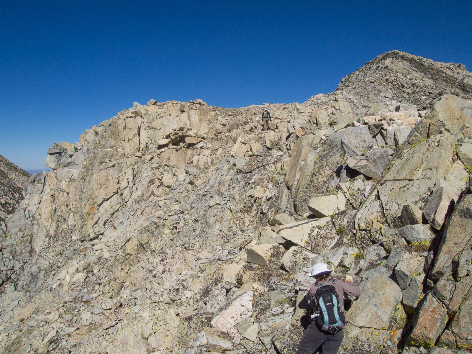 Bill and Stella climb over granite rubble toward the summit.  Photo courtesy of Frank Paysen.