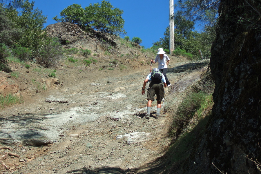Piaw opts to descend backward on the steep, loose road from North Peak.
