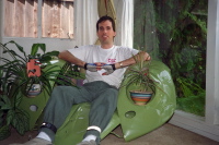 Bill sits in Scott Wiley's sculpture, the hood of a VW bug.