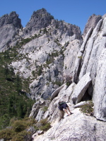 David scrambles up to a ledge amongst the crags.