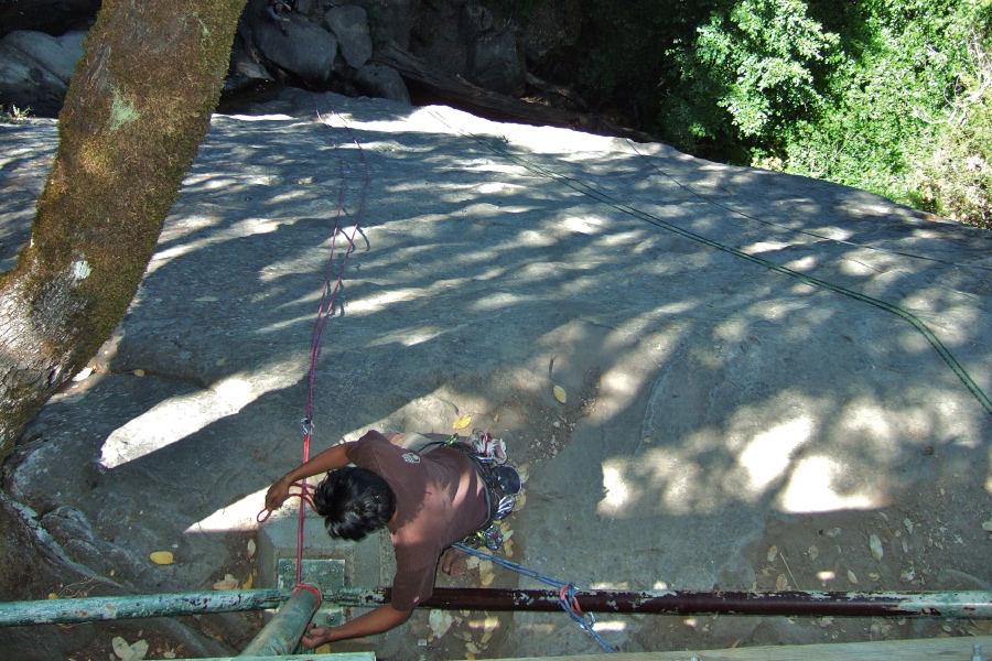 A climber prepares to rappel down the cliff face.