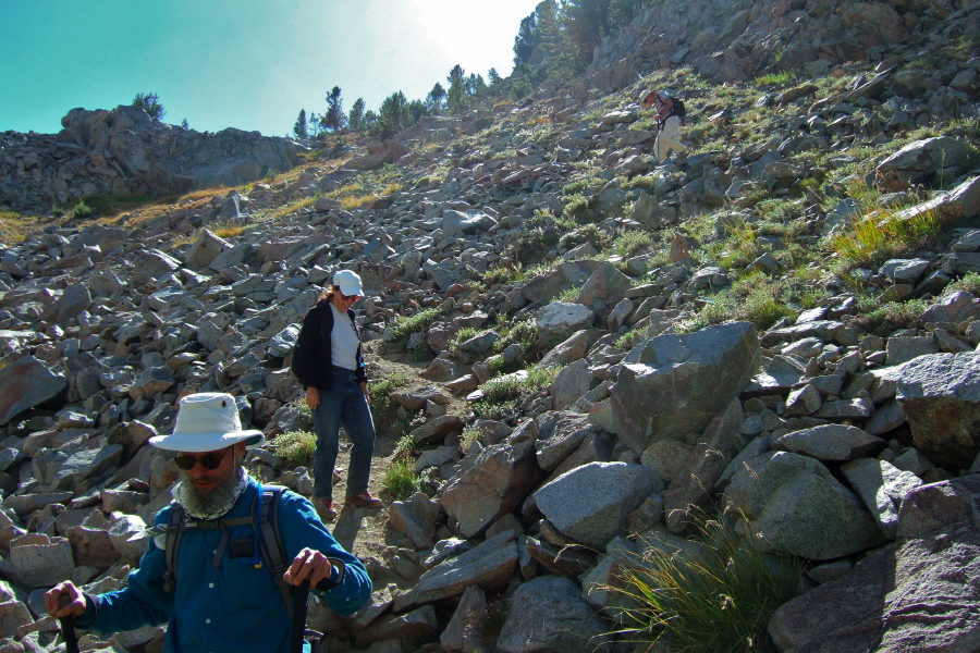 Frank and Stella descend the steep trail; David follows.