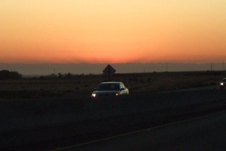 Sunrise on the Sierra peaks casting shadows into the haze.