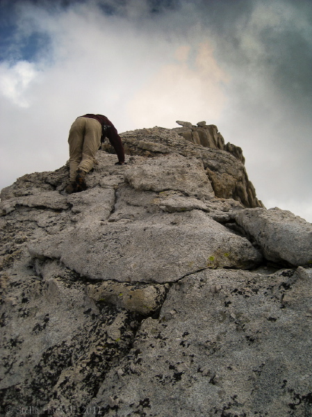 Frank starts up the narrow ridge into thin air.