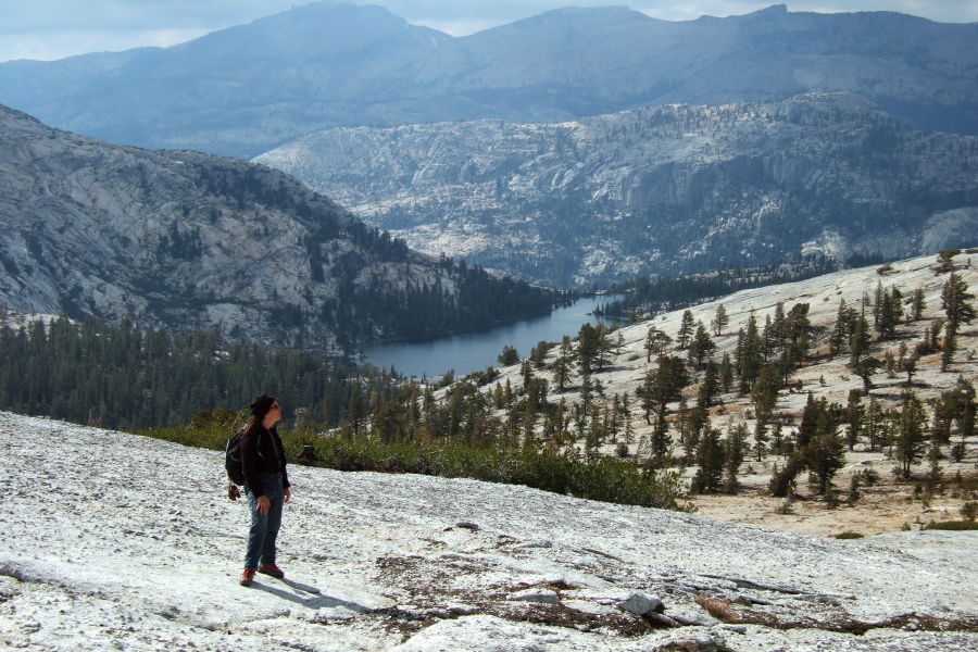 Stella admires Cathedral Peak while hiking down the slabs to the south of the peak.