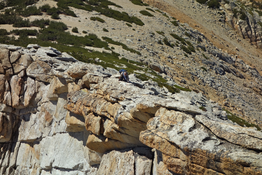 Frank crawls out onto the overhanging rock.