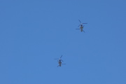 Transport helicopters pass overhead.