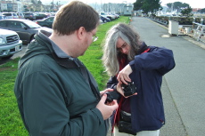 Len helps Lisa change the lens on her camera.