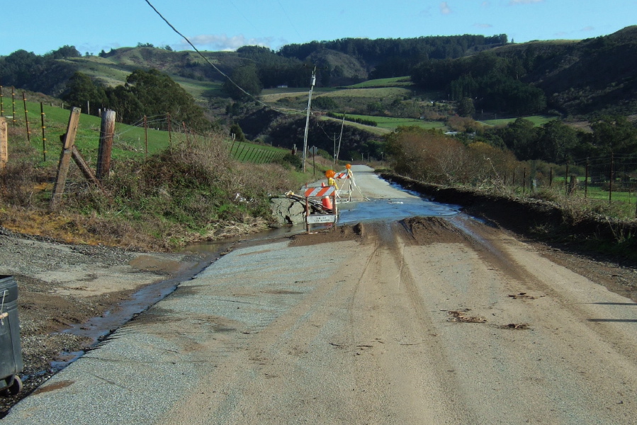 Water and mud stream across Lobitos Cutoff Road.