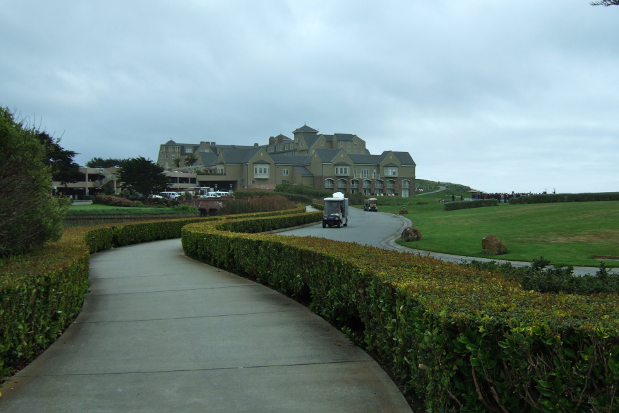 The well-manicured Trail past The Ritz is bordered by manicured hedgerows and is paved with concrete.