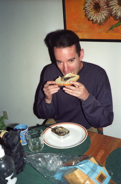 Zach eats his sardine sandwich.