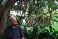 David relaxes on the lanai below a sausage tree.