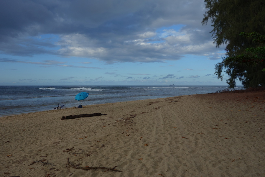 The blue umbrella at Ke'e Beach seen earlier and a cruise ship pass off-shore.