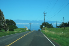 Kohala Mountain Road descends north toward Haleakala (10023ft) on Maui.
