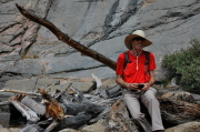 Bill sits on old wood at the outflow of Upper Lamarck Lake.