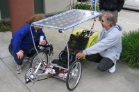 Joel DeCaro shows his solar-charging trike with aero-panniers.