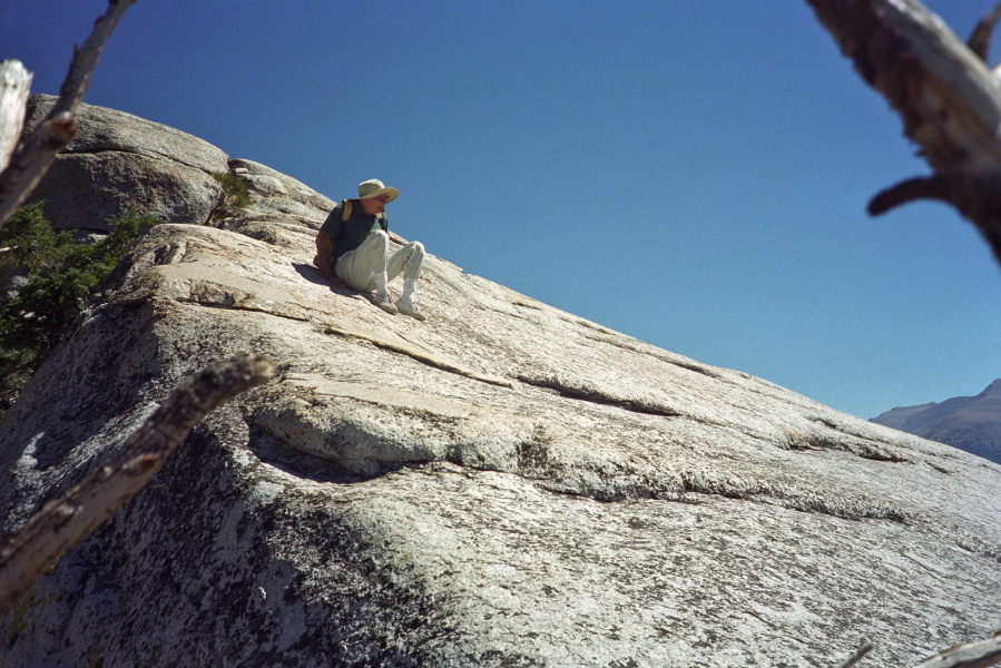 David scoots down the rock to the lower summit on Lembert Dome.