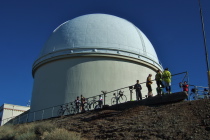Cyclists enjoy the morning sun before the observatory dome.