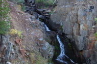 The creek cascades down a narrow slot canyon.