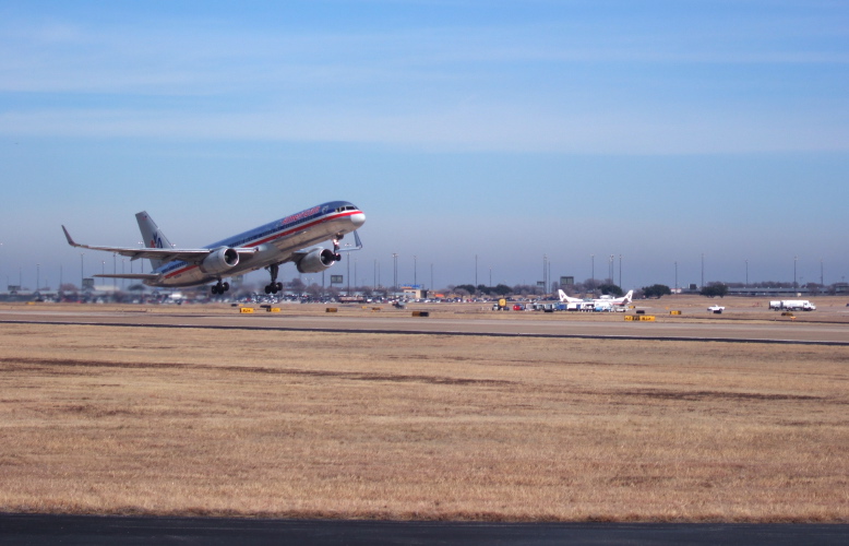 Waiting for another plane to take off before crossing the runway.