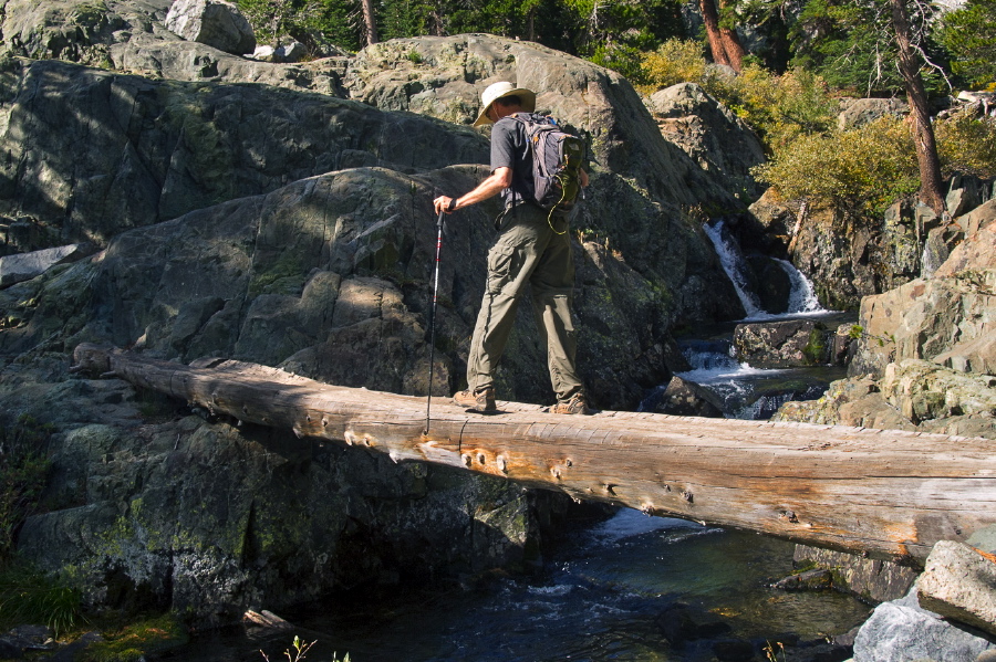 Bill crosses the two-log bridge over Shadow Creek.
