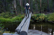 Bill crosses Minaret Creek on a two-log bridge.