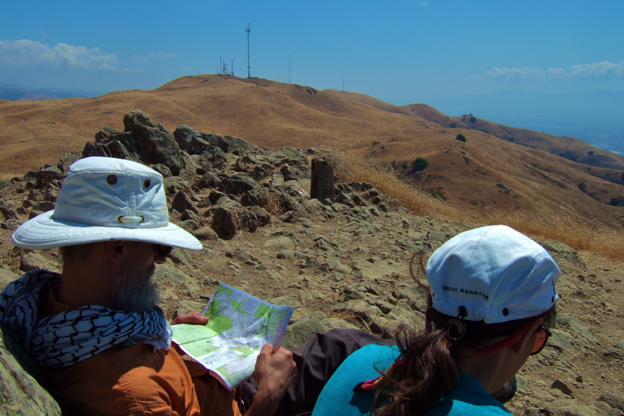 Frank studies the map while Stella watches something on the ground.