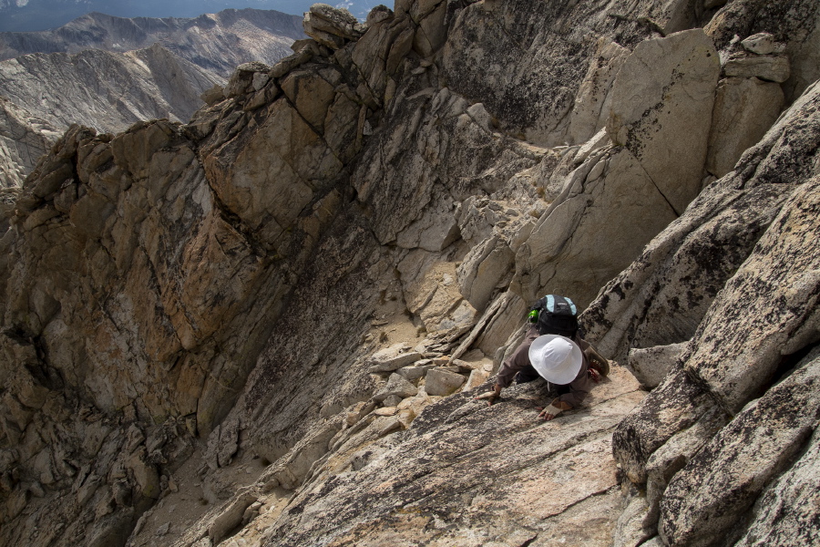 Stella descends to a ledge off the south side of the arête.