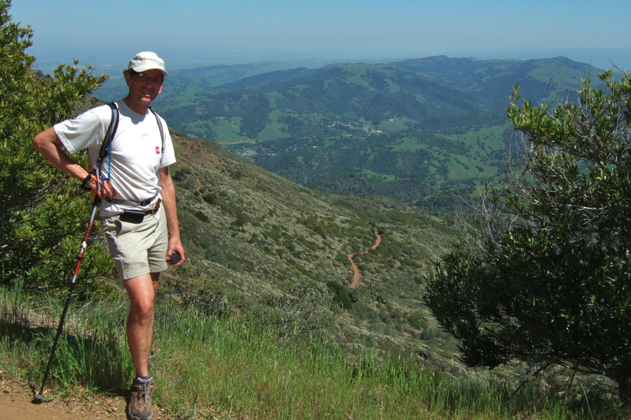 Bill P. shows off the flowering white ceanothus covering the southwest slope of North Peak.