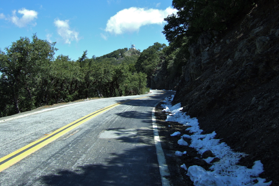 Snow lingers in the shade on the road to Copernicus Peak and its lookout tower, visible in the background.