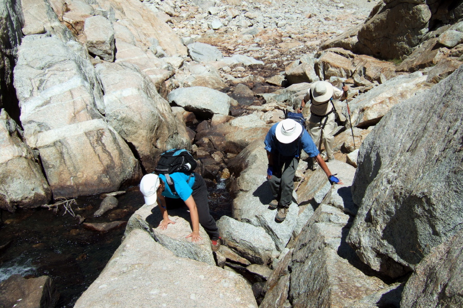 Stella, Frank, and David climb over the last boulders at the head of the canyon before upper Conness Lake.