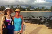 Kay and Laura stand near a resting monk seal on Po'ipu Beach.