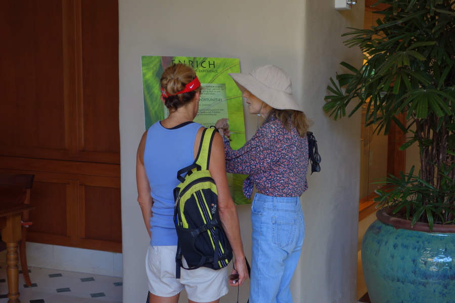 Laura and Kay examine a poster on the wall.