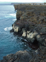 Lava flows form cliffs at the water's edge.