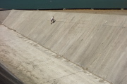 Boy confidently climbs a lower section of the spillway wall.