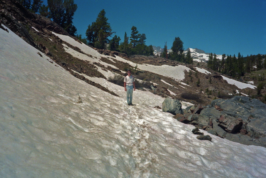 Derek hikes down the snowfield to Garnet Lake.