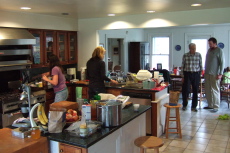 Janice and Laura work in the kitchen while David and Bob talk.
