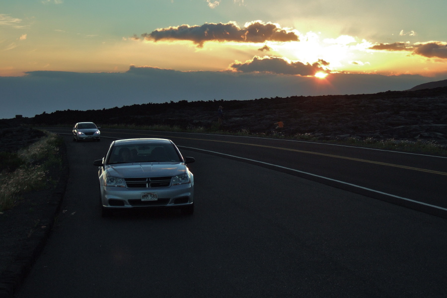 The sun sets behind some clouds.