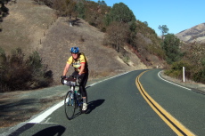 A cyclist climbs the grade to Bear Valley.